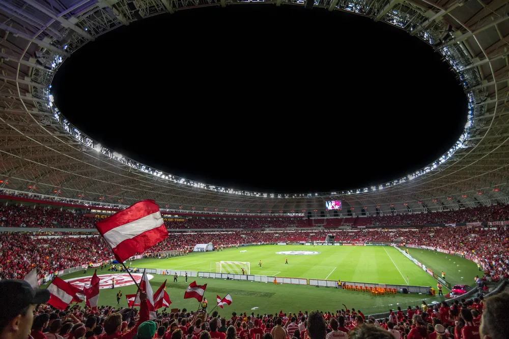 Estadio de fútbol lleno con banderas en la tribuna